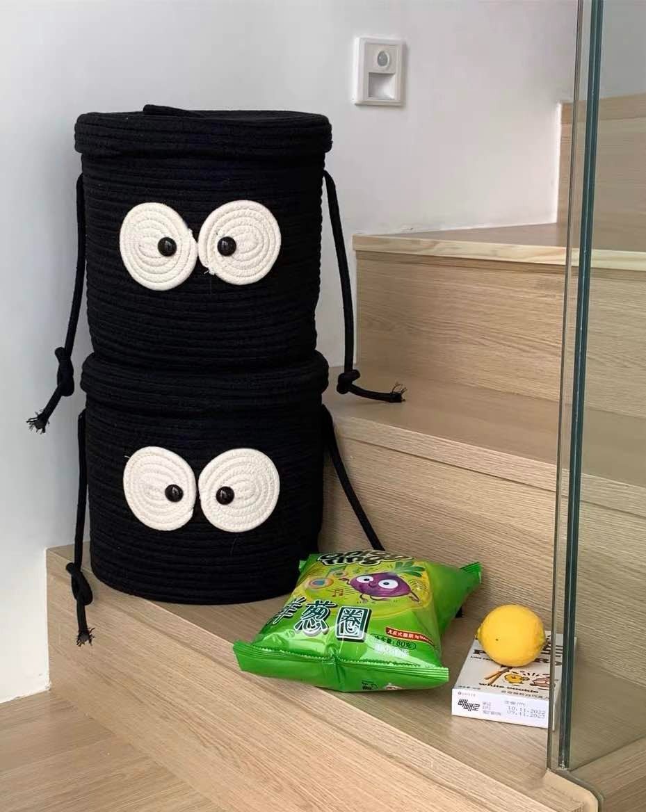 Niedlicher, skurriler Wäschekorb aus gewebtem Stoff mit großen Kulleraugen und Kohlballen-Motiv